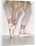 Ballerina adjusting toe shoe by Anonymous