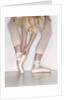 Ballerina adjusting toe shoe by Anonymous