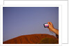 Tourist photographing Ayers Rock in the Australian Outback by Anonymous