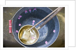Ladling peach blossoms from a water pail by Anonymous