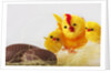 Toy chickens looking at chocolate eggs by Anonymous