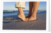 Feet of couple hugging on beach by Anonymous