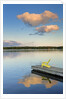 Clouds reflected in Silent Lake with Muskoka chair on dock by Anonymous