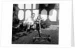 A father show his two year old daughter how to mow the lawn, ca. 1956 by Anonymous