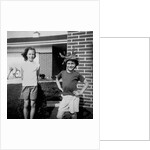 Brother and sister playing in front of their house, ca. 1965 by Anonymous
