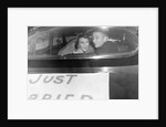 A couple peers out of the back window on their wedding day, ca. 1953 by Anonymous