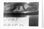 A couple peers out of the back window on their wedding day, ca. 1953 by Anonymous