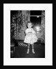 A little girl stands by the Christmas tree clutching her doll, ca. 1955 by Anonymous