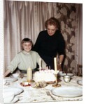 Nine year old girl is about to blow out the candles on her while her mom watches, ca. 1962 by Anonymous