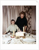 Nine year old girl is about to blow out the candles on her while her mom watches, ca. 1962 by Anonymous