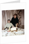 Nine year old girl is about to blow out the candles on her while her mom watches, ca. 1962 by Anonymous