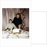 Nine year old girl is about to blow out the candles on her while her mom watches, ca. 1962 by Anonymous
