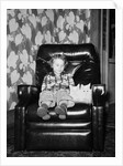 Young girl sits with her two cats in a leather chair, ca. 1960 by Anonymous