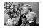 Two brothers look at a candle on a Christmas tree in Germany, ca. 1950 by Anonymous