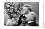 Two brothers look at a candle on a Christmas tree in Germany, ca. 1950 by Anonymous
