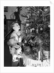Two brothers look at a Christmas tree in their living room in Germany, ca. 1949 by Anonymous