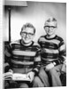 Two brothers pose with a book on their living room couch, ca. 1953 by Anonymous