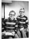 Two brothers pose with a book on their living room couch, ca. 1953 by Anonymous