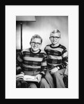 Two brothers pose with a book on their living room couch, ca. 1953 by Anonymous