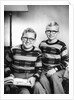 Two brothers pose with a book on their living room couch, ca. 1953 by Anonymous