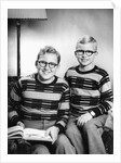Two brothers pose with a book on their living room couch, ca. 1953 by Anonymous