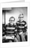 Two brothers pose with a book on their living room couch, ca. 1953 by Anonymous