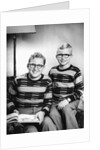 Two brothers pose with a book on their living room couch, ca. 1953 by Anonymous
