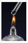 Test tube with liquid, over flame by Anonymous