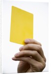 Hand holding yellow card by Anonymous