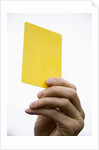 Hand holding yellow card by Anonymous