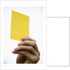 Hand holding yellow card by Anonymous