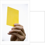 Hand holding yellow card by Anonymous