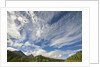 Cumulus and cirrus clouds above mountains by Anonymous