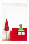 Stack of Christmas gifts on sofa by Anonymous