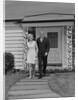 Mature couple walking on sidewalk front of house by Anonymous