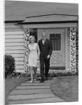 Mature couple walking on sidewalk front of house by Anonymous