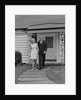 Mature couple walking on sidewalk front of house by Anonymous