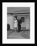 Mature couple walking on sidewalk front of house by Anonymous