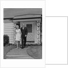 Mature couple walking on sidewalk front of house by Anonymous