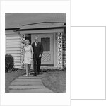 Mature couple walking on sidewalk front of house by Anonymous