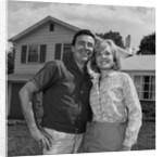 Happy couple portrait man woman smiling in front of home by Anonymous