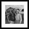 Happy couple portrait man woman smiling in front of home by Anonymous