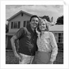 Happy couple portrait man woman smiling in front of home by Anonymous