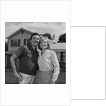 Happy couple portrait man woman smiling in front of home by Anonymous
