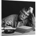 Young man studying reading books leaning on arm by Anonymous