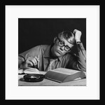 Young man studying reading books leaning on arm by Anonymous