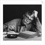 Young man studying reading books leaning on arm by Anonymous