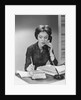Brunette business woman sitting desk talking telephone writing note on calendar by Anonymous