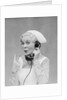 Smiling blond nurse with surprised expression talking on telephone holding up two fingers by Anonymous