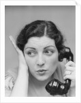 Young brunette woman with surprised expression hand to head talking on telephone by Anonymous